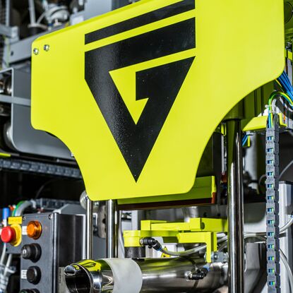 Greif-Velox BVP – detail view of the filling spout with yellow machine housing and Greif-Velox logo mark